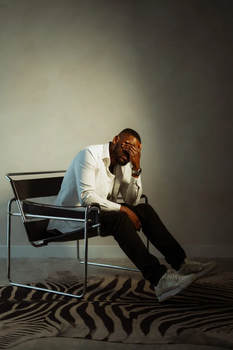 Man on Wassily chair, hand over face