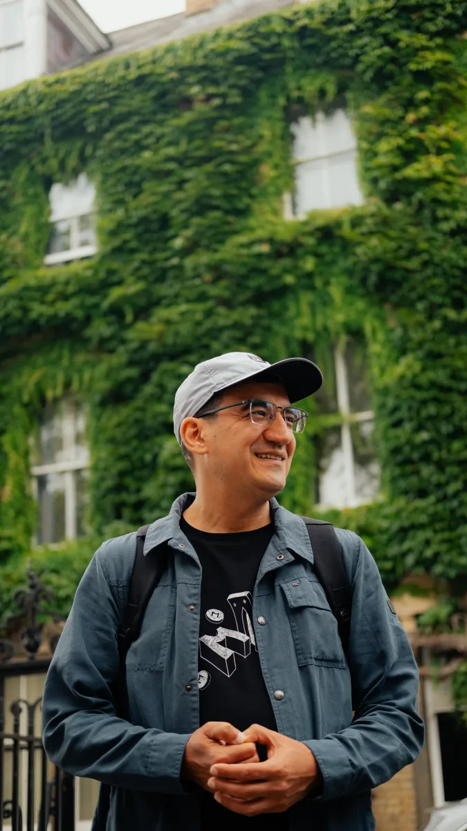 Smiling man by an ivy-covered building